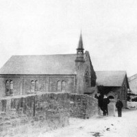 Kidwelly Bridge Looking north along Kidwelly Town Bridge with Trinity Church in the Background. The bridge consists of a double arched 19th century road bridge, over the Gwendraeth Fach estuary. Hidden beneath the present structure is an earlier medieval bridge of which a pointed arch is visible. Trinity Chapel was built in 1866, in the Simple Gothic style of the gable entry type, to the design of architect T.W.A. Evans of Kidwelly. (source Colfein)